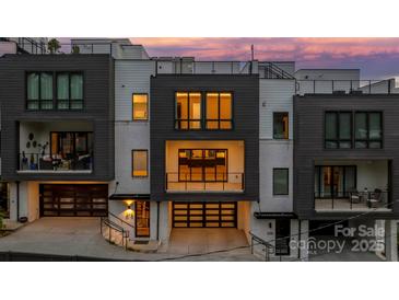 Modern townhouse with a dark garage door, balcony, and a combination of white brick and dark siding, set against a colorful dusk sky at 614 Queens Rd, Charlotte, NC 28207