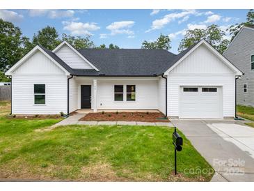 Charming, newly constructed single-Gathering home features a manicured lawn and an attached garage at 722 English St, Monroe, NC 28110