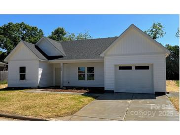 Charming one-story home with white siding, an attached garage, and a well-manicured lawn at 722 English St, Monroe, NC 28110