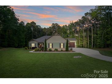 Charming single-story home with a well-manicured lawn and lovely landscaping at 7358 Bay Cove Ct, Denver, NC 28037