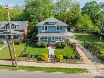 Charming blue two-story home featuring a well-manicured front yard with a classic picket fence at 822 W Front St, Statesville, NC 28677