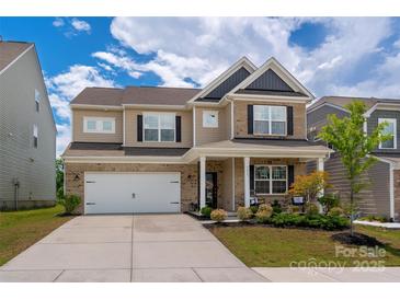 Charming two-story home featuring a brick and siding facade, well-manicured lawn, and an attached two-car garage at 9613 Fire Bellied Ct, Lancaster, SC 29720
