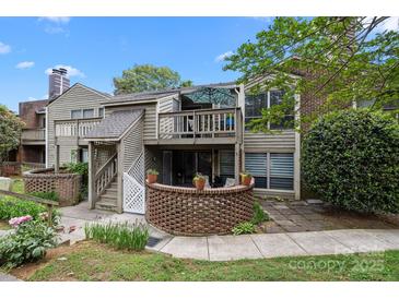 Charming townhouse with brick accents, a second-floor balcony, and manicured landscaping at 1608 Sharon W Rd # 55, Charlotte, NC 28210