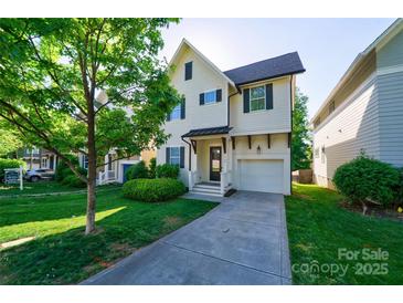 Charming two-story home featuring a well-manicured lawn, attached garage and covered entryway, creating curb appeal at 1909 Summey Ave, Charlotte, NC 28205