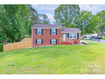 Charming brick home with black shutters, green lawn, and wooden fence at 3219 Spring Valley Dr, Gastonia, NC 28052