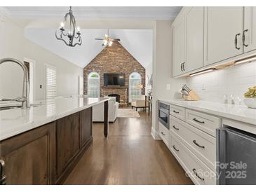 Open-concept kitchen with a large island and views of the living room with a stone fireplace at 502 Fly Fisher Dr, Salisbury, NC 28147