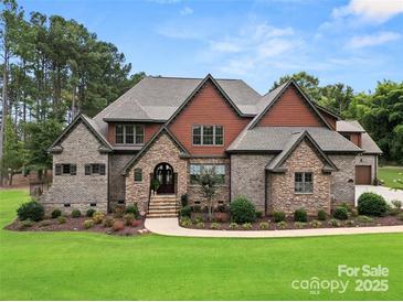 Stunning brick home featuring lush landscaping, a stone facade, and a welcoming front porch at 664 Bellegray Rd, Clover, SC 29710
