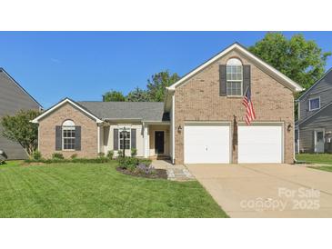 Charming two-story brick home with a well-manicured lawn and two-car garage at 6724 Long Nook Ln, Indian Trail, NC 28079