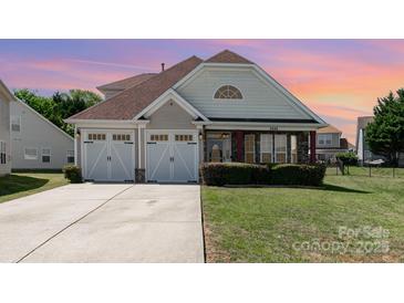 Charming two-story home featuring an attached two-car garage, manicured lawn, and stone-accented porch at 9588 Marquette Nw St, Concord, NC 28027
