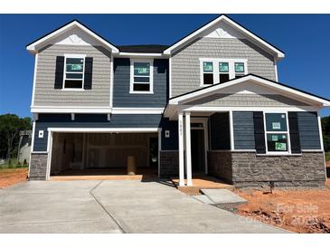Two-story home with gray and blue siding, stone accents, and an attached two-car garage at 1001 Cunningham Farm Dr, Indian Trail, NC 28079
