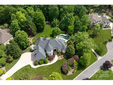 Stunning aerial view of estate home featuring backyard pool surrounded by mature trees and lush landscaping at 1001 Medinah Ct, Waxhaw, NC 28173