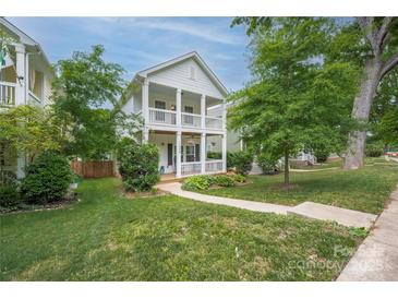 Charming two-story home boasts a double porch, well-manicured lawn, and lush greenery at 12224 Huntersville Concord Rd, Huntersville, NC 28078