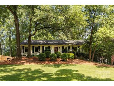 Charming one-story home with a well-manicured lawn and mature trees at 1427 Worcaster Pl, Charlotte, NC 28211