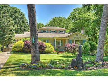 Charming home featuring a well-manicured lawn and vibrant flower beds at 2115 Mecklenburg Ave, Charlotte, NC 28205
