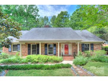 Charming brick home with black shutters and a well-manicured front yard at 2235 Ramblewood Ln, Charlotte, NC 28210
