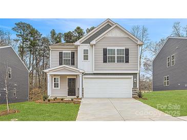 Charming two-story home featuring a two-car garage and inviting front porch, set in a landscaped yard at 118 Dorian Pl, Troutman, NC 28166