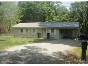 Charming ranch home featuring gravel driveway, metal roof, and mature landscaping at 146 Barclay Ln, Mooresville, NC 28115