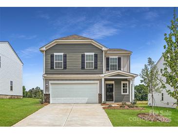 Charming two-story home with a two-car garage, well-maintained lawn, and inviting front entrance at 155 Astor St, Troutman, NC 28166