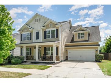 Inviting two-story home with a charming front porch, well-manicured lawn, and a two-car garage at 15807 Foreleigh Rd, Huntersville, NC 28078