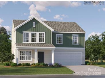 Charming two-story home with green and beige siding, manicured lawn, and a two-car garage at 1611 Spring Lot Dr, Edgemoor, SC 29712
