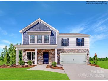Two-story home featuring a stone and siding facade, covered front porch and two car garage at 1623 Spring Lot Dr, Edgemoor, SC 29712