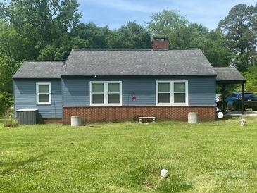 Charming single-story home with blue siding, brick foundation and a large yard at 1658 Hillcrest Ave, Lancaster, SC 29720