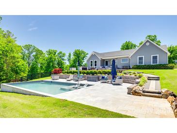 Gorgeous backyard pool with blue umbrellas and lounge chairs in a manicured outdoor space at 1780 Sierra Rd, York, SC 29745
