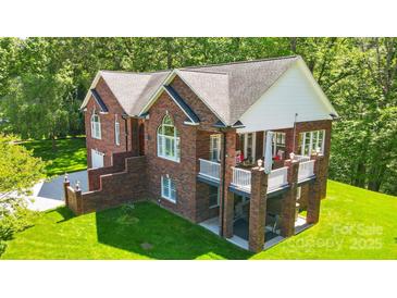 Aerial view of a brick house with a deck, showcasing its architectural design and well-kept outdoor space at 221 Grayrock Dr, Statesville, NC 28677