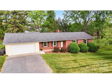 Charming brick ranch home featuring an attached garage, well-manicured lawn, and mature landscaping at 326 N Greenbriar Rd, Statesville, NC 28625