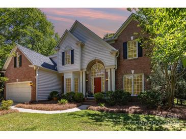 Charming brick and siding home featuring a red front door and well-maintained landscaping at 3710 Cheleys Ridge Ln, Charlotte, NC 28270