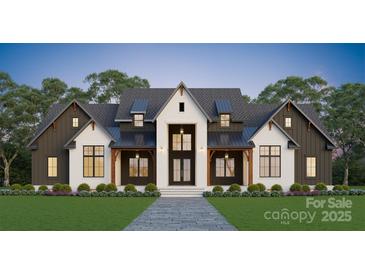 Striking two-story home featuring a gray roof, white brick, dark accents, and a manicured lawn at 611 Wisteria Vines Trl, Fort Mill, SC 29708