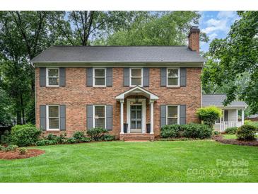 Charming two-story brick home with a well-manicured lawn and symmetrical landscaping at 1209 Alfred St, Charlotte, NC 28211