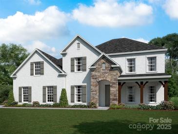 Charming two-story home featuring a brick facade, stone entryway, shuttered windows, and a well-manicured lawn at 12104 Sessile Dr # Oak0015, Mint Hill, NC 28227
