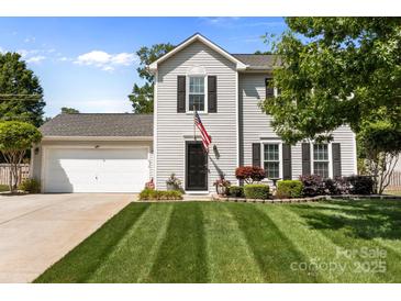 Charming two-story home featuring a well-manicured lawn, an attached two-car garage, and lovely curb appeal at 150 Pleasant Grove Ln, Mooresville, NC 28115