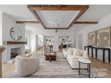 Bright, open living room with wood beam ceiling, fireplace, and hardwood floors perfect for entertaining or cozy Gathering time at 1817 Union St, Charlotte, NC 28205