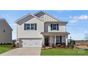 Charming two-story home with attached garage, inviting porch, and beautifully landscaped front yard at 2585 Blue Sky Meadows Dr, Monroe, NC 28110