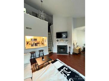 Bright living area with fireplace, dark hardwood floors, and an open kitchen design at 300 S Cedar St # 2, Charlotte, NC 28202