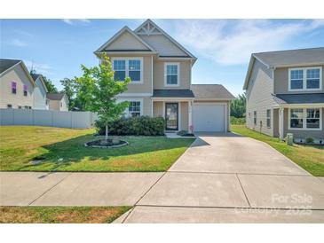 Charming two-story home boasts a well-manicured lawn, inviting curb appeal, and attached garage at 3578 Saddlebrook Dr, Midland, NC 28107