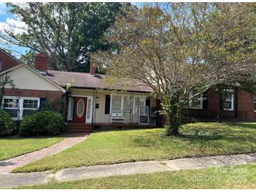 Charming single-story home featuring a cozy front porch and well-maintained lawn at 411 Woodlawn Ave, Gastonia, NC 28052
