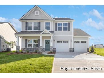 Charming two-story home with a manicured lawn, two-car garage, stone accents and inviting covered front porch at 5594-C Galloway Dr # 99P, Stanfield, NC 28163