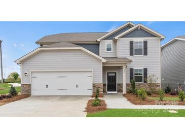 Charming two-story home with gray siding, stone accents, and a two-car garage at 566 Mountain View Dr, Monroe, NC 28110