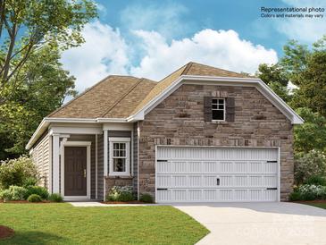 Charming single-story home featuring a stone facade, a two-car garage, and a well-manicured front lawn at 8441 Norman Forest Rd, Lancaster, SC 29720