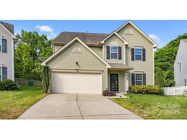 Charming two-story home featuring light green siding, black shutters, and a well-manicured front yard at 9437 Tavistock Ct, Matthews, NC 28105