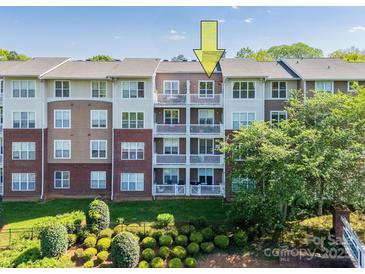 Apartment building with brick and siding, featuring multiple balconies on a sunny day at 1000 E Woodlawn Rd # 408, Charlotte, NC 28209