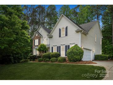 Two-story home with white siding, black shutters, and a well-maintained lawn, complemented by mature trees at 109 Braxton Gate Ct, Mount Holly, NC 28120