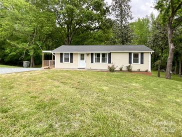 Charming single-story home featuring a well-manicured front yard with green grass and a small porch at 1105 S Church S St, Monroe, NC 28112