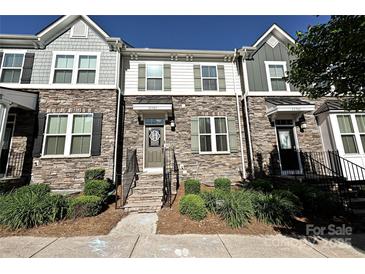 Charming townhome showcasing a stone facade, well-manicured landscaping, and inviting entryway with steps at 11741 Blessington Rd, Huntersville, NC 28078