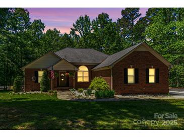 Charming brick home with manicured lawn and inviting entrance, nestled among mature trees at 1800 Oriole Ct, Monroe, NC 28112