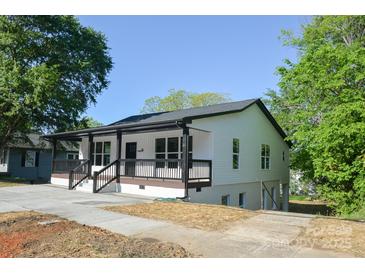 Newly renovated exterior with a black railed porch, crisp white siding and neutral concrete driveway at 307 N Catawba St, Lancaster, SC 29720