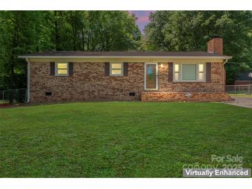 Charming brick home featuring a well-manicured lawn and mature trees, offering great curb appeal at 393 Carson Dr, Gastonia, NC 28052